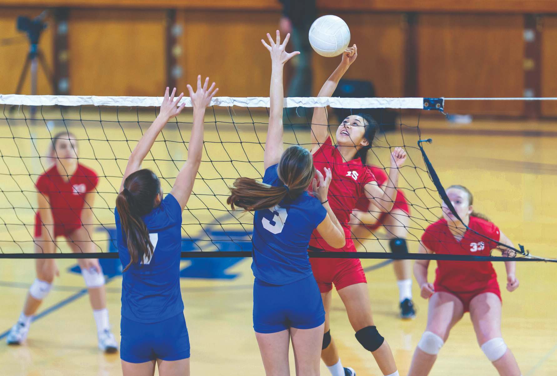 girls playing gym volleyball