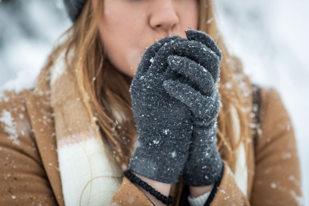 764620514-femalecold woman wearing gloves in snow