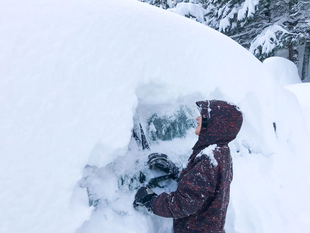 Person digging snow off car