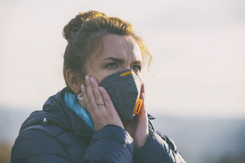 769058140-istock-1297387983 woman holding mask to face