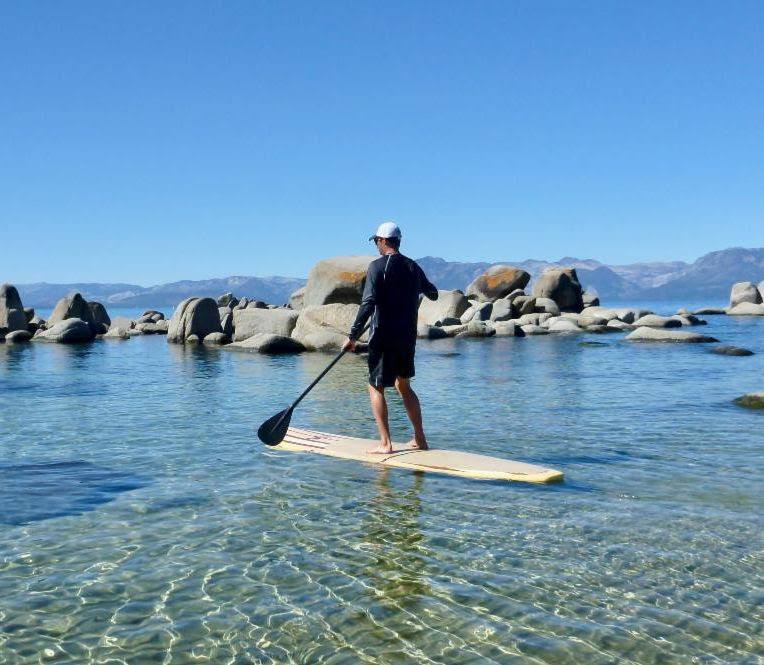 Person stand up paddling on lake tahoe