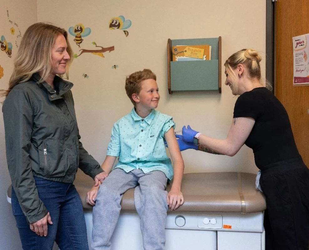 flushot child receives flu shot from provider while guardian supports