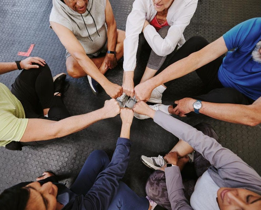 traintogether circle of people putting fists together