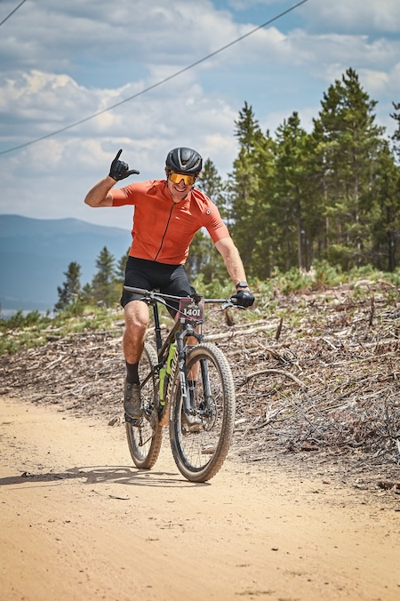 Dr. Joshua Pfent giving hang loose sign with hand during Leadville 100 MTB Race
