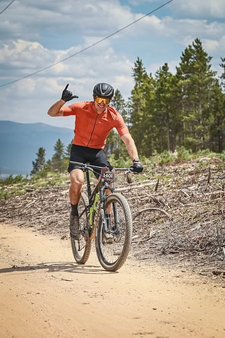 IMG_1128 web news Dr. Joshua Pfent giving hang loose sign with hand during Leadville 100 MTB Race
