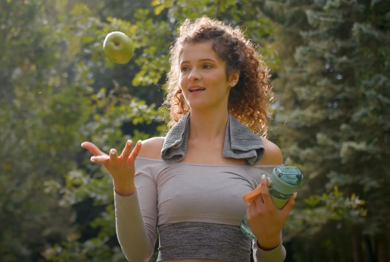 athlete throws apple into air above her palm