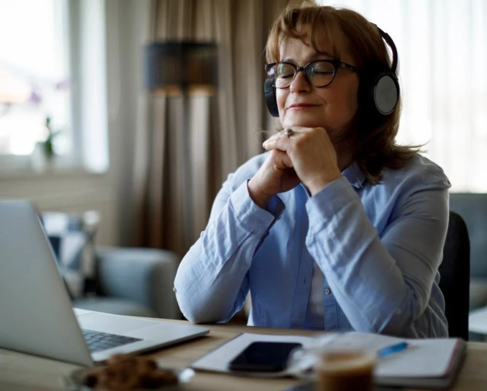 crediblemind woman listens on headphones while closing her eyes