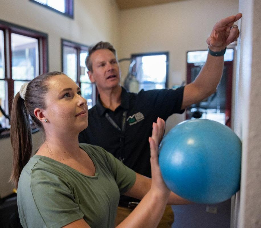 patient performs physical therapy will ball on the wall