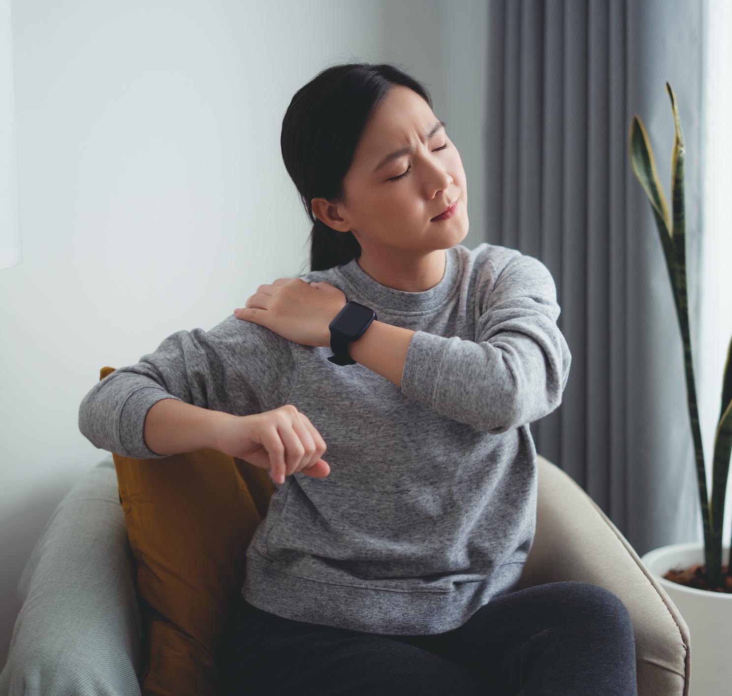shoulderpain woman holds her shoulder with look of pain on her face