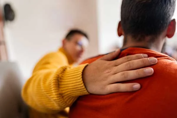 support person with a hand on teens shoulders in supp