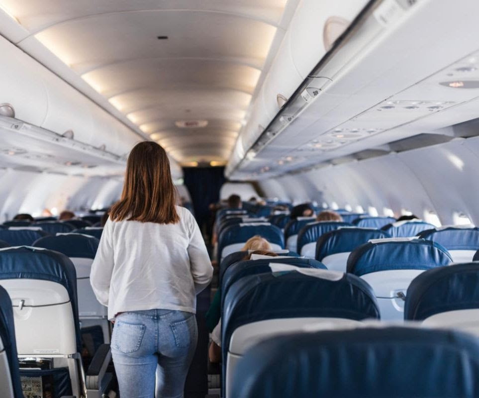 airplaneaisle woman walks down airplane aisle