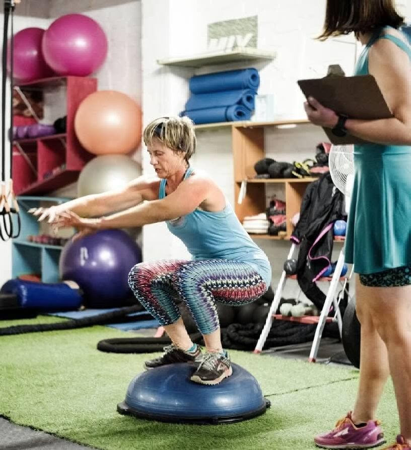 woman squats on bosu