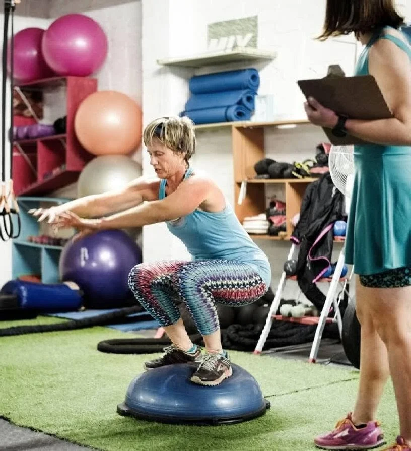 woman squats on bosu