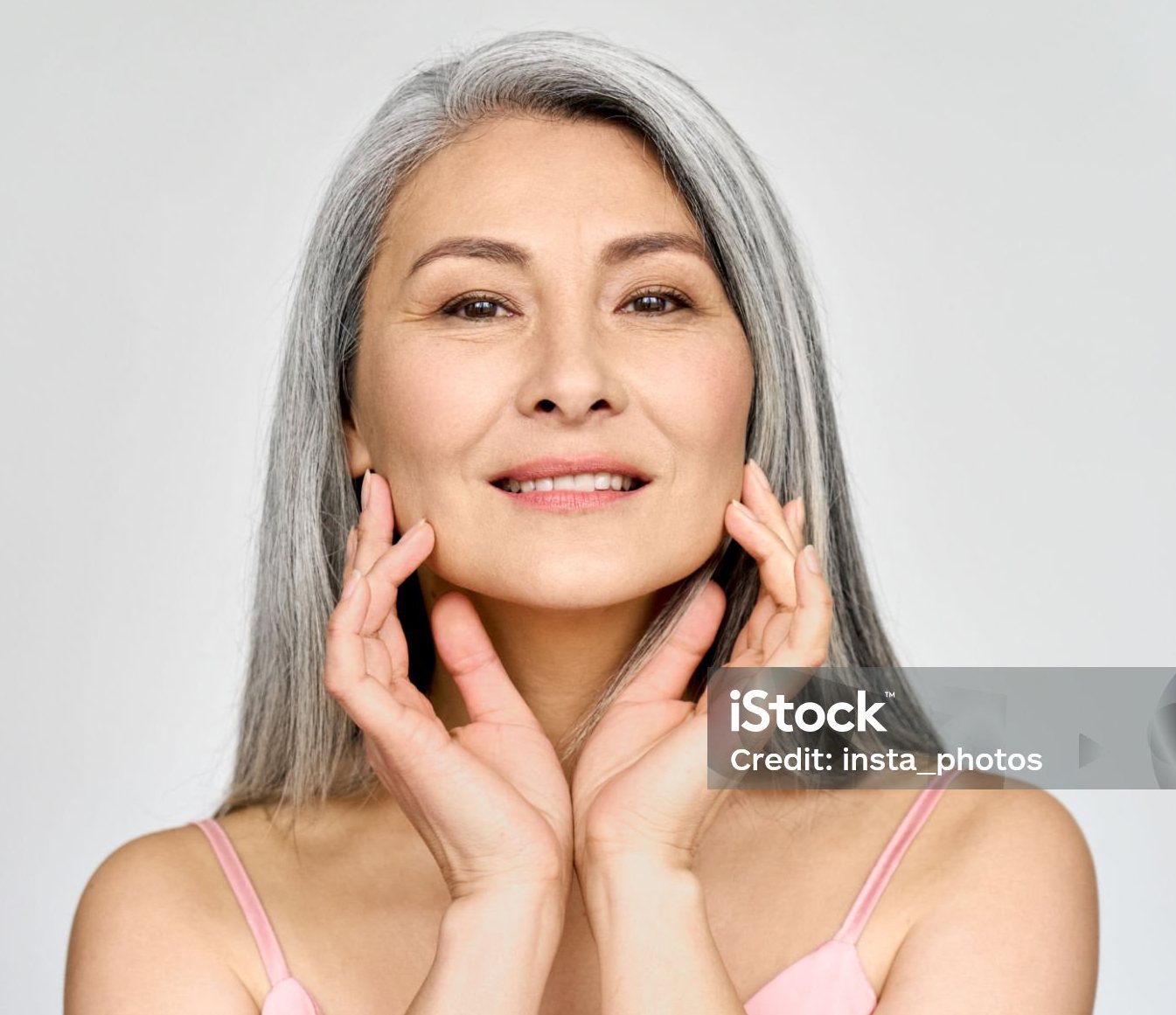 woman touches face with her fingertips softly