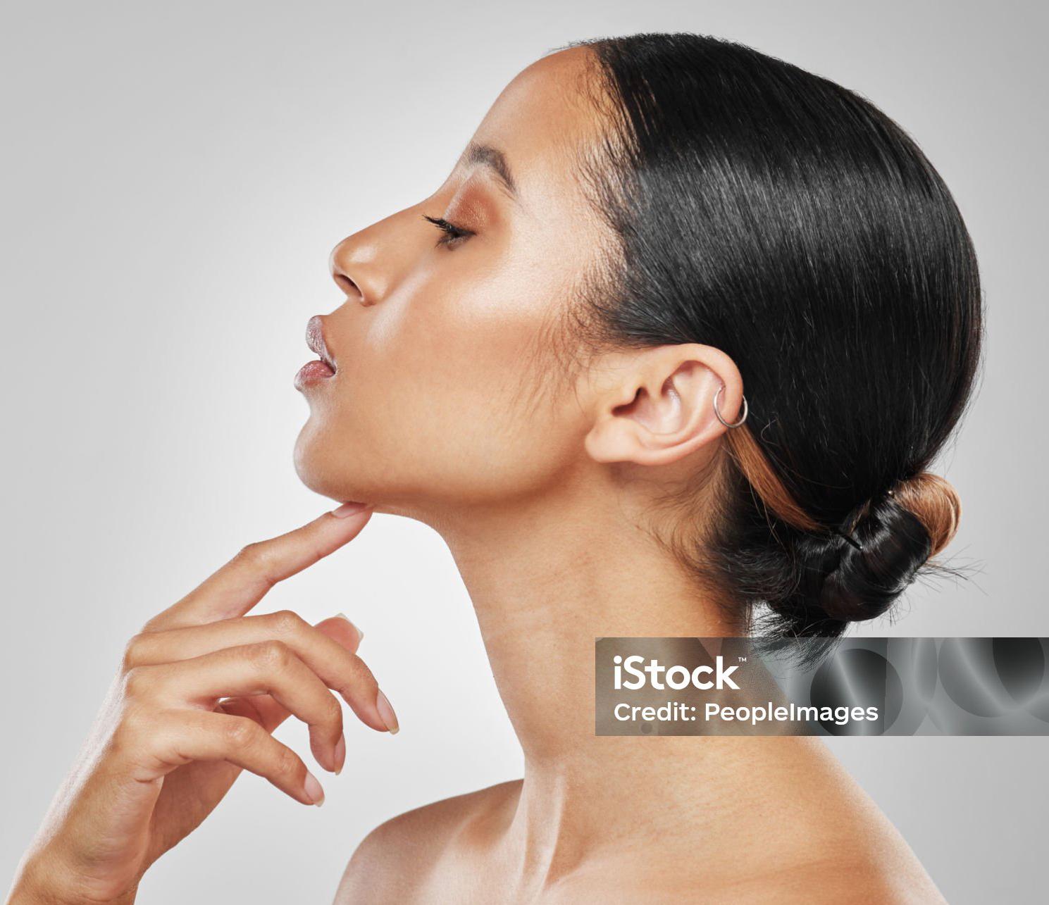 woman's face in profile as she holds index finger under chin