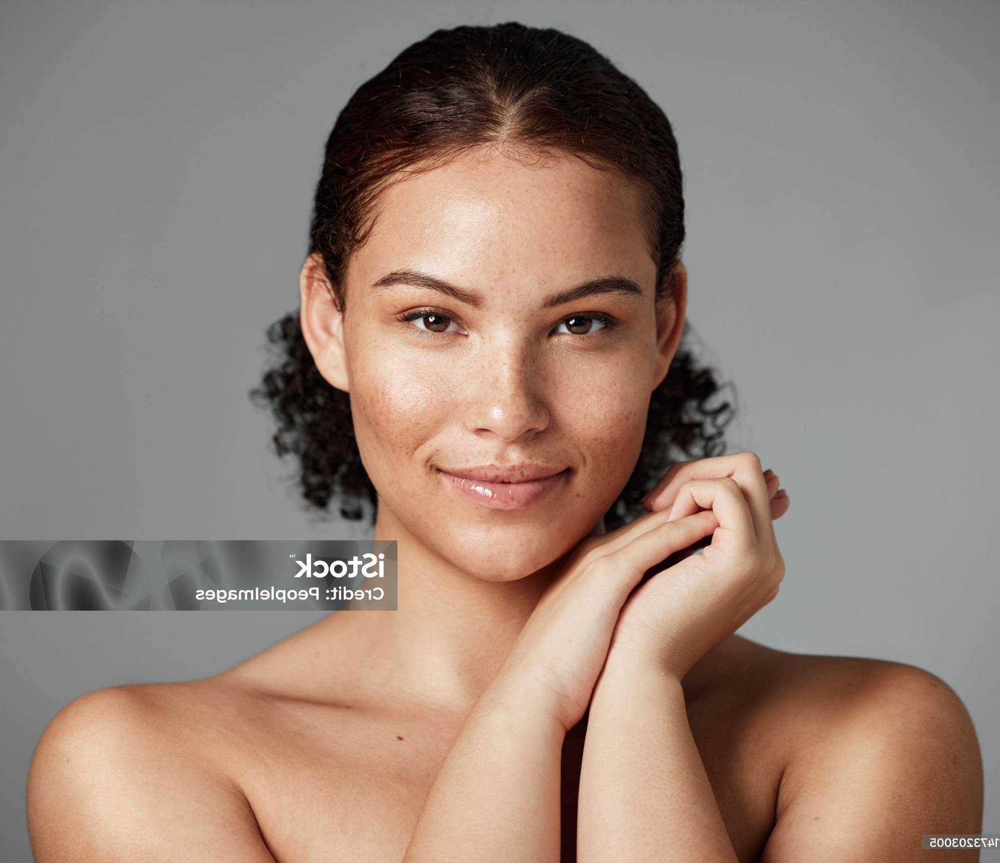 woman holds hands near her cheek