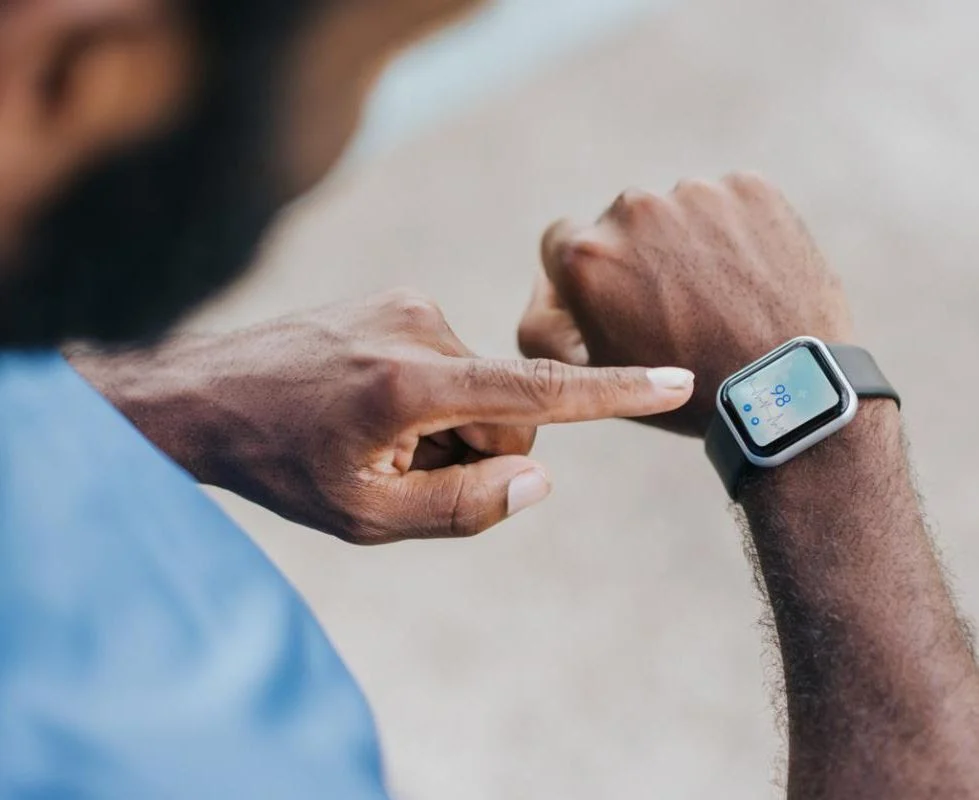 man points to smartwatch on wrist