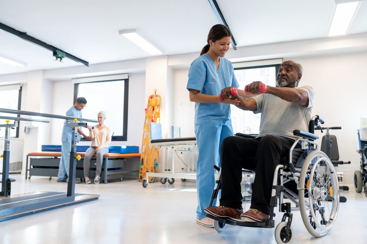 strokerehab patient does rehabilitation exercise in wheelchair with support from provider