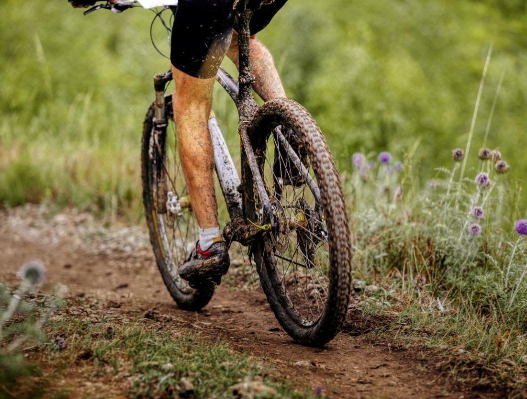 mountain bike rides on a muddy trail