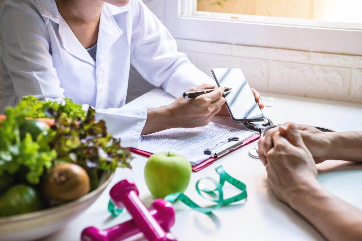 consultdiet dietician consults patient with apples and salad on the desk