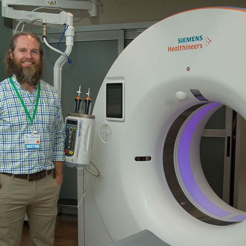 dr-fountain-ct doctor standing next to CT machine