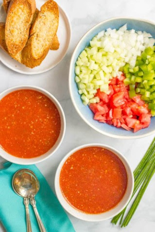 gaspacho bowls of gazpacho with toasted bread and diced vegetable toppings