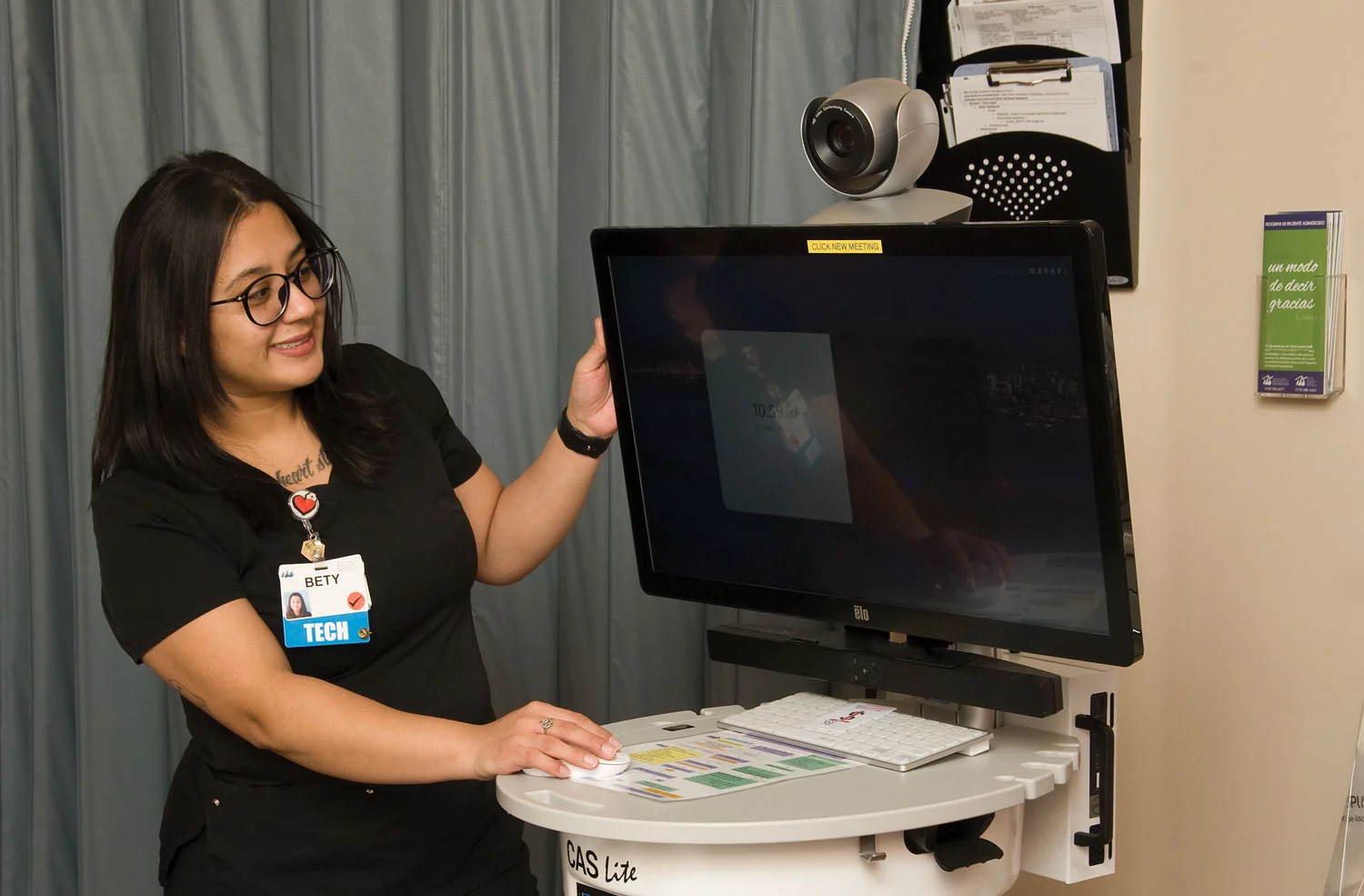 tech-showing-screen-to-patient healthcare worker looking at screen in emergency room