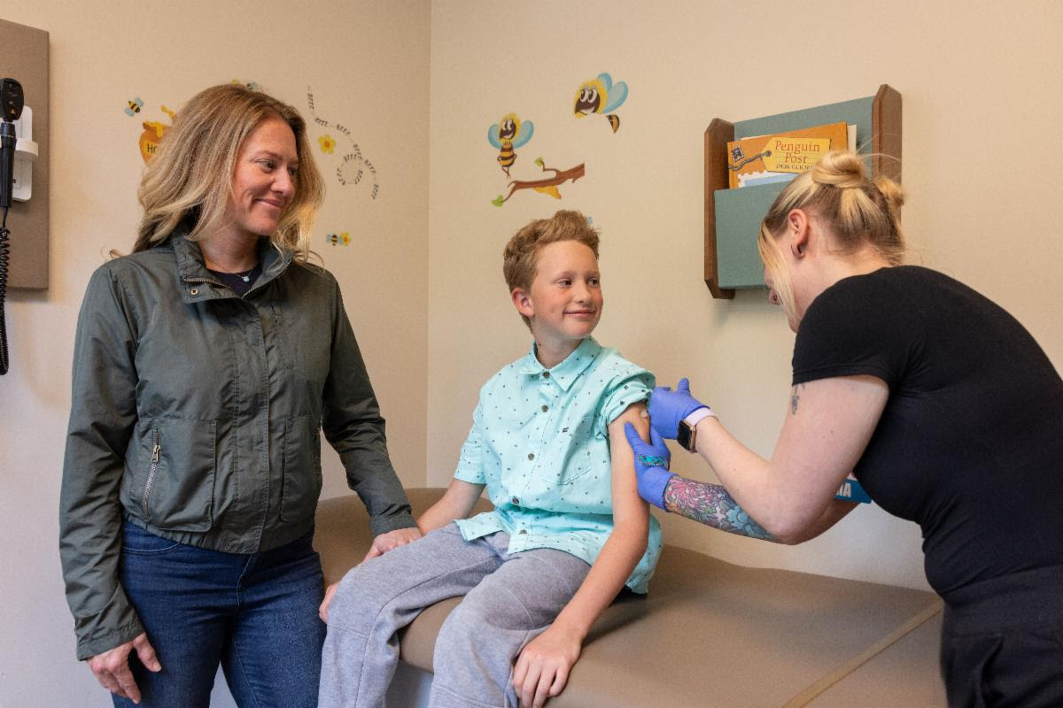 vaccine child receives vaccine with mom nearby