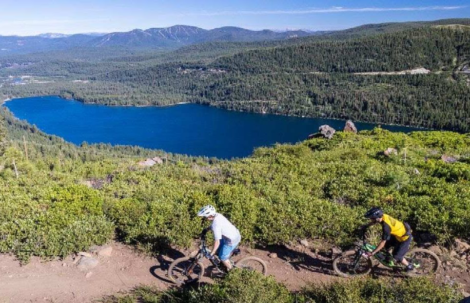 biking 2 mountain bike riders on a trail overlooking donner lake