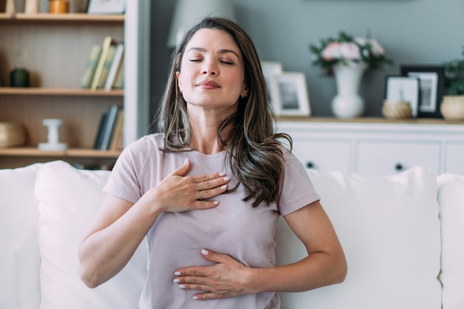 Woman doing a breathing technique in living room