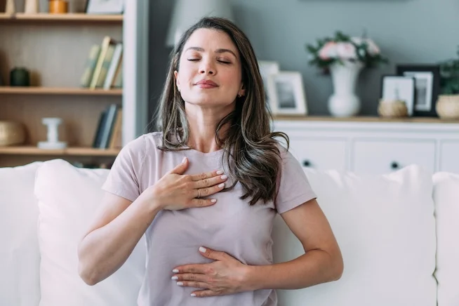 iStock-2169836748 web Woman doing a breathing technique in living room