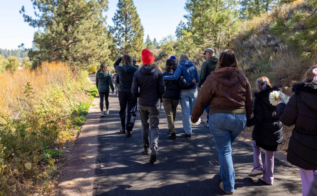 Walkers on a paved scenic path, from behind