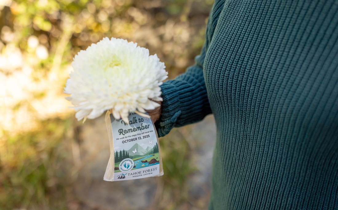Participant holding a white chrysanthemum with event tag