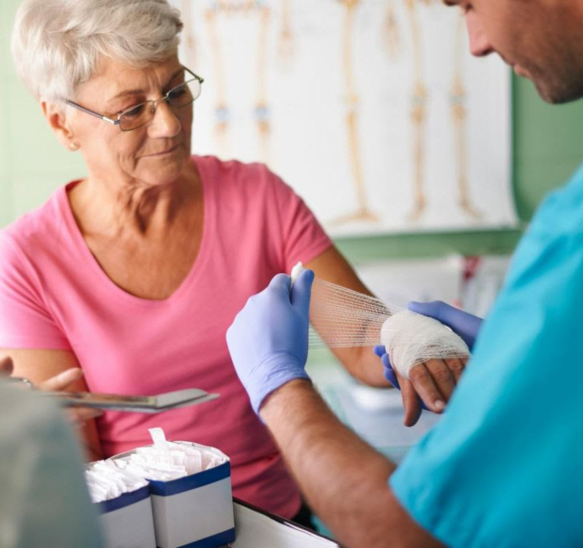 woundcare provider wraps patient's hand in gauze